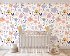 a baby's room with floral wallpaper and a crib in the foreground