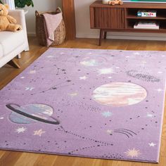 a purple rug with planets and stars on it in front of a television set,