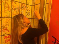 a woman writing on the wall with graffiti