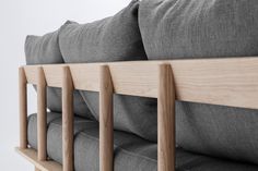 a close up view of the back of a couch with wooden arms and pillows on it