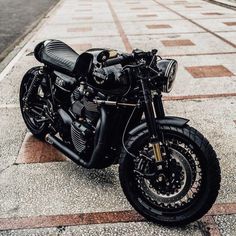 a black motorcycle parked on the sidewalk in front of a building