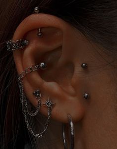 a close up of a person with some piercings on their ear and behind the ear