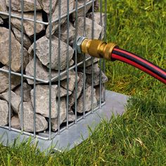 a red hose connected to a metal cage filled with rocks