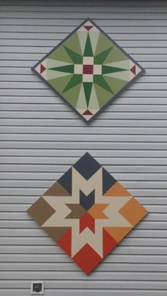 two decorative tiles on the side of a garage door