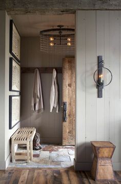 a wooden bench sitting in the middle of a room next to a light on a wall