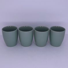 four green cups sitting next to each other on a table