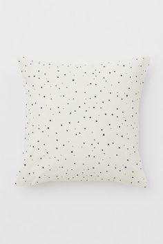 a white pillow with black dots on it