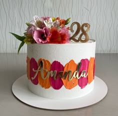 a decorated birthday cake with flowers and the number 28 on it's bottom tier