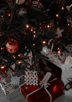 a black and white photo of a christmas tree with presents under it on the floor