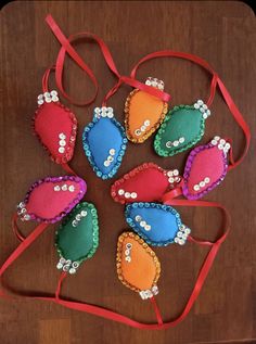 several different colored handbags on a wooden table with red ribbon and beaded decorations