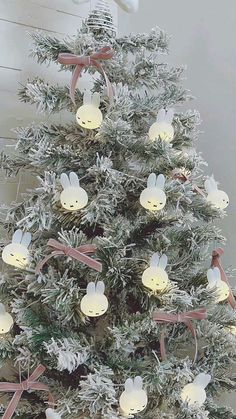 a small christmas tree with lights on it's branches and bunny ears hanging from the top