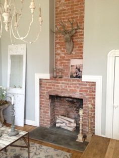 a living room filled with furniture and a fire place in front of a brick fireplace