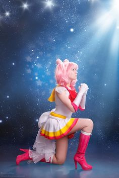 a woman with pink hair is sitting on the ground in front of stars and bright lights