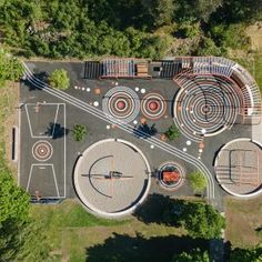 an aerial view of a basketball court in the middle of a park with trees and benches