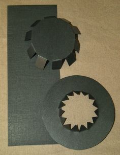 two circular pieces of paper sitting next to each other on top of a sheet of cloth