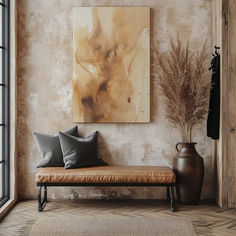 a painting hangs on the wall next to a bench with pillows and two vases