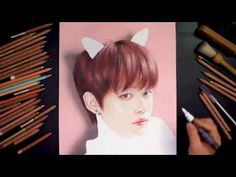 a drawing of a person with cat ears on it's head next to colored pencils and crayons