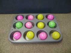 a muffin tin filled with lots of different colored balls