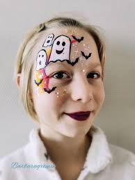 a girl with her face painted to look like ghost