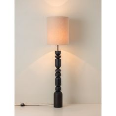 a lamp that is on top of a table next to a light fixture with a white shade