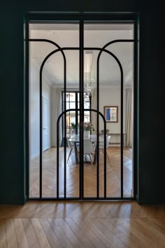 an open door leading to a dining room with a chandelier hanging from the ceiling