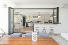 an open concept kitchen and dining room with wood table