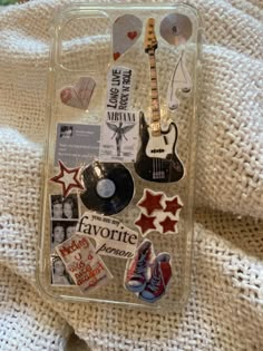 an iphone case with various stickers and magnets attached to it on a blanket