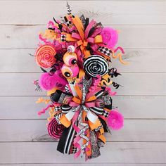 a colorful wreath with candy and lollipops is hanging on the side of a wall