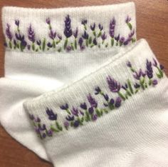 two white socks with purple flowers on them