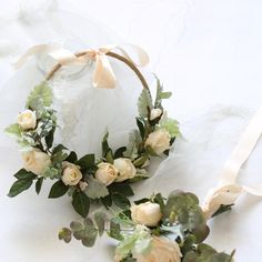 two wreaths with white roses and greenery on them