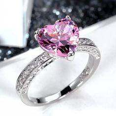 a pink heart shaped ring with diamond accents