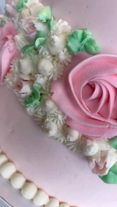 a pink cake with white and green decorations