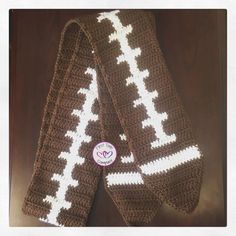 two brown and white crocheted scarfs sitting next to each other