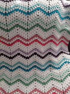 a crocheted blanket is laying on the floor