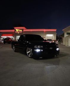 a black truck parked in front of a fast food restaurant