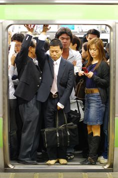 a group of people standing next to each other on a subway