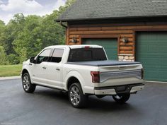 a white truck parked in front of a garage