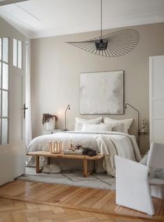 a bedroom with a bed, two chairs and a coffee table