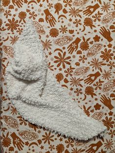 a white towel is laying on top of a floral wallpaper