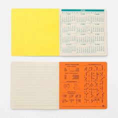 two notebooks with yellow and orange paper on them, one has a calendar in the middle