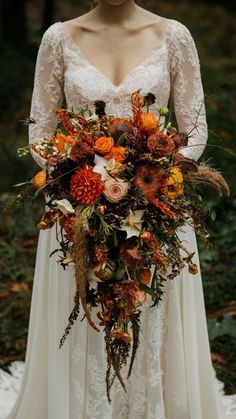 a woman in a wedding dress holding a bouquet with orange and yellow flowers on it