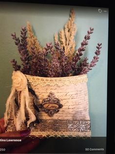 a person holding up a piece of fabric with flowers in it