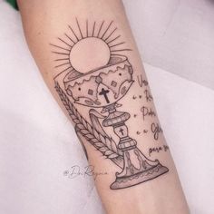 a tattoo on the arm of a person with a cross and bread in front of it