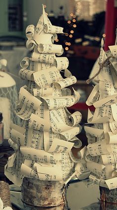 there are two christmas trees made out of old sheet music paper on top of each other