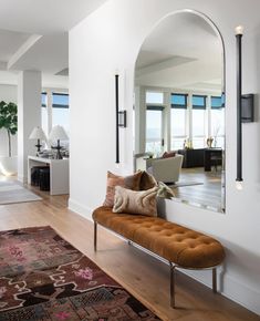 a living room filled with furniture and a large mirror on the wall next to it