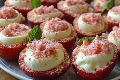 strawberry cupcakes with white frosting and sprinkles on a plate