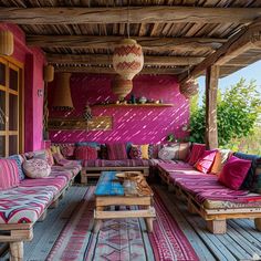 an outdoor living area with couches, tables and rugs