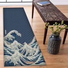 a rug with the great wave on it next to a table and vases filled with flowers