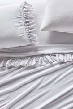 white bedding with ruffled edges and pillows