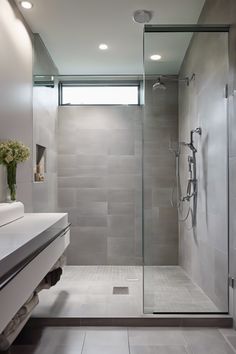 Modern bathroom with walk-in shower, glass door, and a minimalist design.